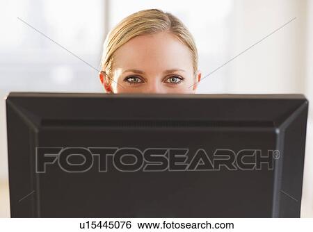 Businesswoman peeking from behind computer View Large Photo Image Stock Photograph - Businesswoman peeking from behind computer. Fotosearch