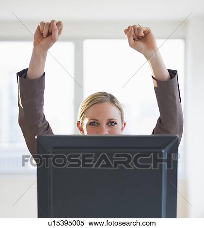 Stock Photography - Businesswoman peeking from behind computer. Fotosearch