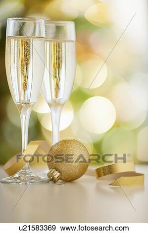 Stock Photo - Champagne glasses with christmas bulb. Fotosearch
