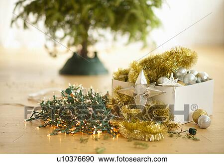 Stock Image - Christmas tree and christmas ornaments on floor. Fotosearch