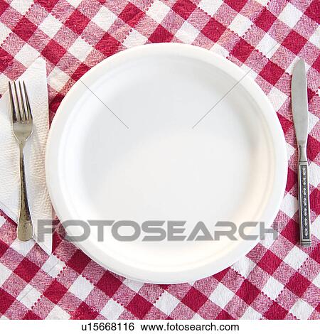 Stock Photograph - Close up empty plate on checked table cloth. Fotosearch