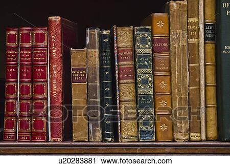 Stock Image - Close up of antique books on shelf. Fotosearch
