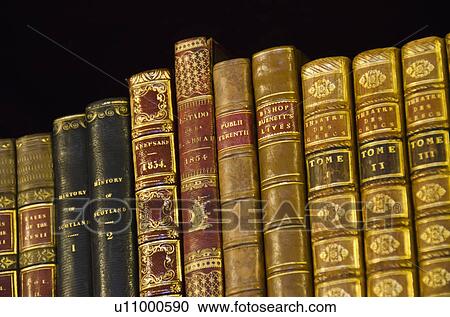 Stock Image - Close up of antique books on shelves. Fotosearch