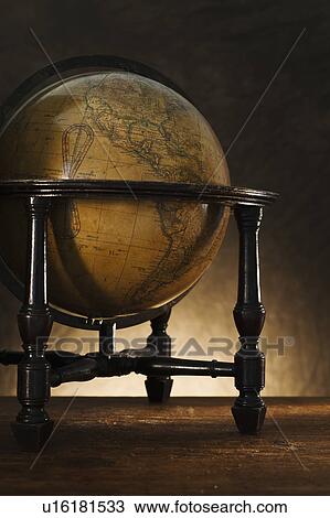 Stock Image - Close up of antique globe on table. Fotosearch