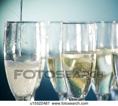 Stock Photo - Close up of champagne flutes on blue background. Fotosearch
