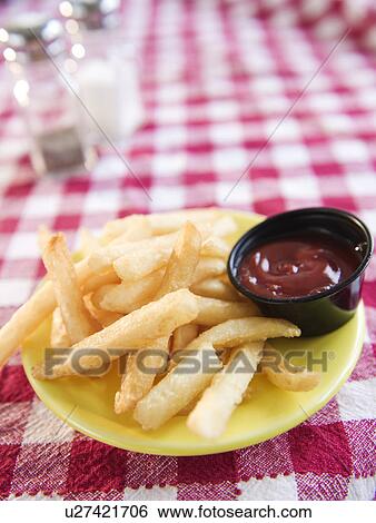 Stock Photograph - Close up of french fries on checked table cloth. Fotosearch