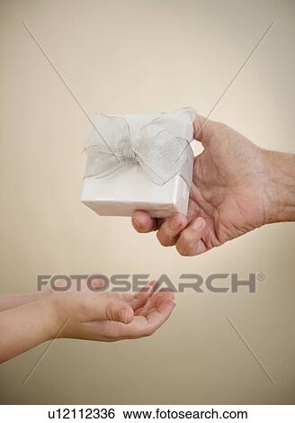 Close up of hands of grandfather and grandson (8-9) with gift View Large Photo Image Stock Photograph - Close up of hands of grandfather and grandson (8-9) with gift. Fotosearch