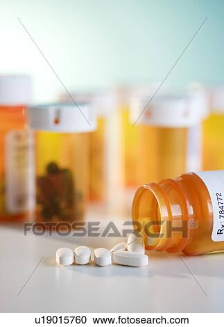 Stock Image - Close up of pills and pill containers. Fotosearch