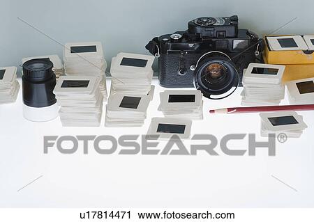 Stock Image - Close up of slides and camera on light box. Fotosearch