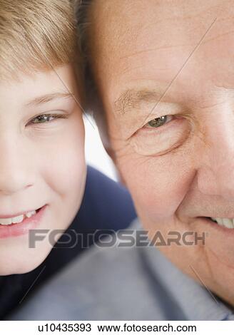 Stock Image - Close up of smiling faces of grandfather and grandson (8-9) . Fotosearch