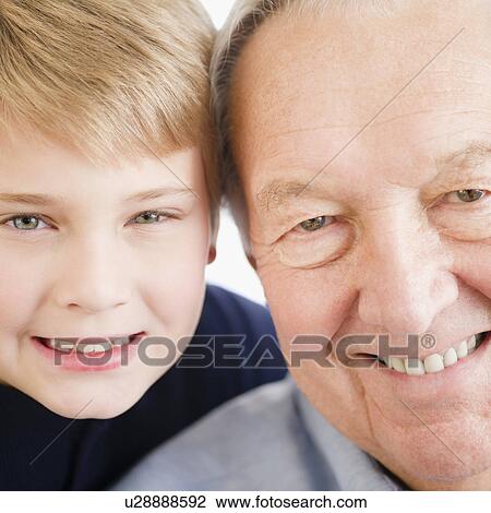 Stock Image - Close up of smiling faces of grandfather and grandson (8-9) . Fotosearch