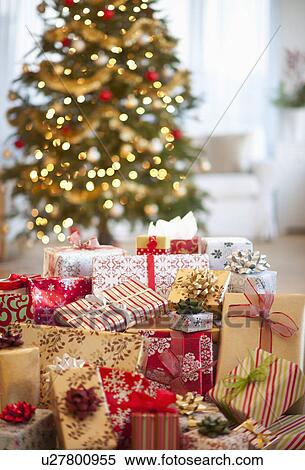 Stock Photography - Colorful gifts and christmas tree in the background. Fotosearch