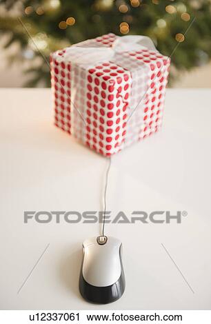 Stock Image - Computer mouse connected to Christmas gift. Fotosearch