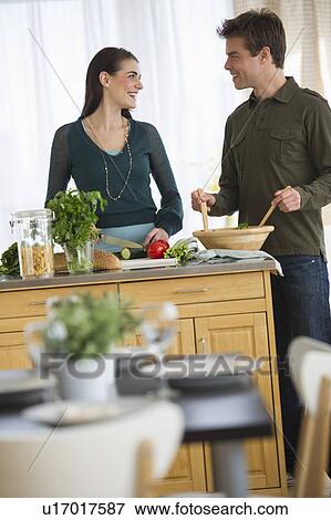 Stock Photo - Couple cooking in kitchen. Fotosearch