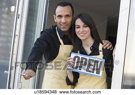 Couple holding open sign View Large Photo Image Stock Photo - Couple holding open sign. Fotosearch