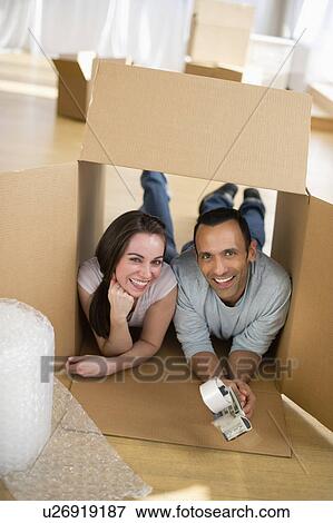Stock Photo - Couple lying inside cardboard box. Fotosearch
