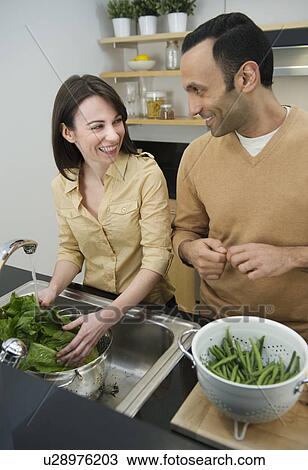 Stock Image - Couple preparing food in kitchen. Fotosearch