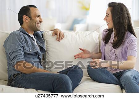 Stock Photo - Couple sitting on sofa talking. Fotosearch