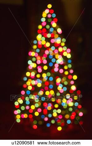 Stock Image - Defocused Christmas tree with colorful lights. Fotosearch