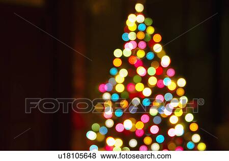 Stock Photo - Defocused Christmas tree with colorful lights. Fotosearch