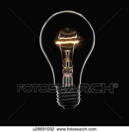 Stock Image - Energy saving bulb on black background, studio shot. Fotosearch