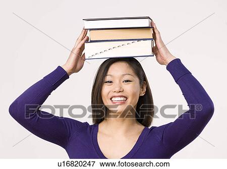 Female student carrying book on head View Large Photo Image Stock Photo - Female student carrying book on head. Fotosearch
