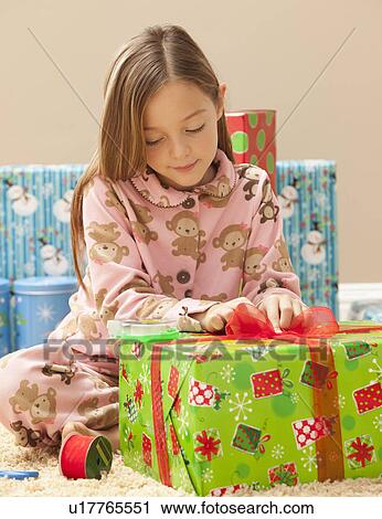 Stock Image - Girl (6-7) preparing Christmas presents. Fotosearch