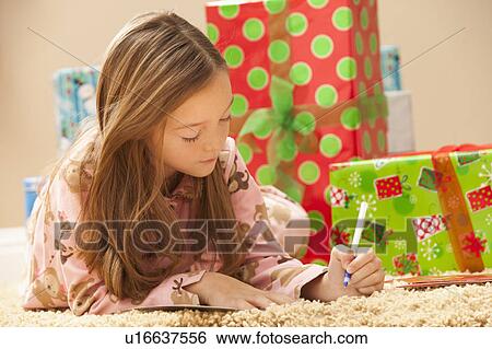Girl (6-7) preparing Christmas presents View Large Photo Image Stock Photograph - Girl (6-7) preparing Christmas presents. Fotosearch