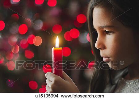 Picture - Girl (8-9) holding candle. Fotosearch