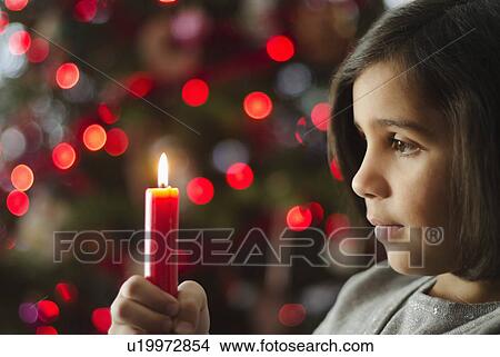 Girl (8-9) holding christmas candle View Large Photo Image Picture - Girl (8-9) holding christmas candle. Fotosearch