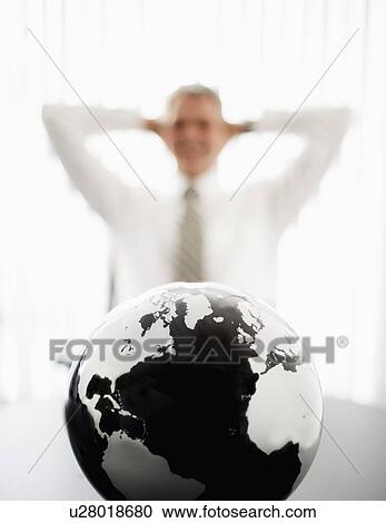 Globe with defocused businessman in background View Large Photo Image Stock Image - Globe with defocused businessman in background. Fotosearch