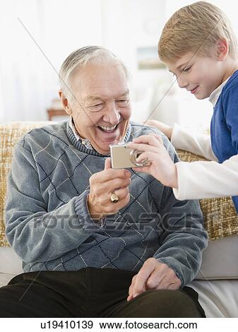 Grandfather and grandson (8-9) holding digital camera View Large Photo Image Stock Photo - Grandfather and grandson (8-9) holding digital camera. Fotosearch