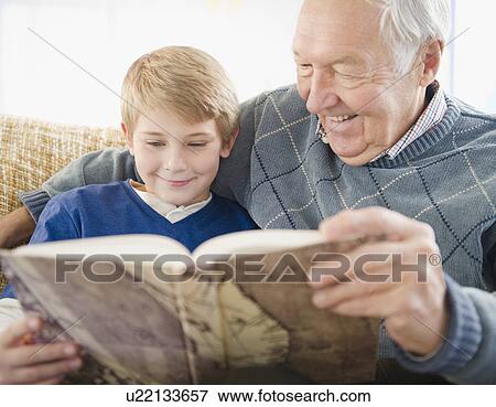 Grandfather and grandson (8-9) reading book View Large Photo Image Stock Photo - Grandfather and grandson (8-9) reading book. Fotosearch
