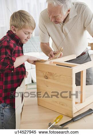 Grandfather and grandson (8-9) improving wooden stool View Large Photo Image Stock Photography - Grandfather and grandson (8-9) improving wooden stool. Fotosearch