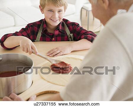 Grandfather and grandson (8-9) preparing pizza View Large Photo Image Stock Photography - Grandfather and grandson (8-9) preparing pizza. Fotosearch