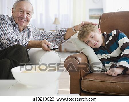 Grandfather stroking grandson (8-9) and watching tv View Large Photo Image Stock Image - Grandfather stroking grandson (8-9) and watching tv. Fotosearch