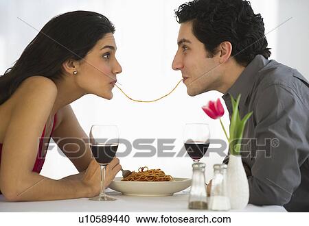 Stock Image - Happy couple eating spaghetti together. Fotosearch