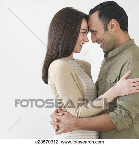 Stock Image - Happy couple embracing, studio shot. Fotosearch