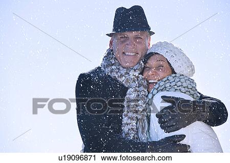Stock Image - Happy mature couple in winter scenery. Fotosearch