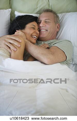Happy mature couple laying in bed View Large Photo Image Stock Image - Happy mature couple laying in bed. Fotosearch