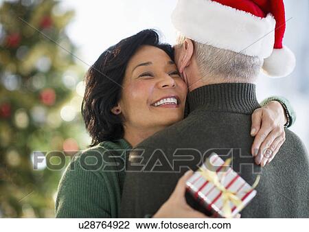 Stock Image - Happy mature couple on christmas time. Fotosearch