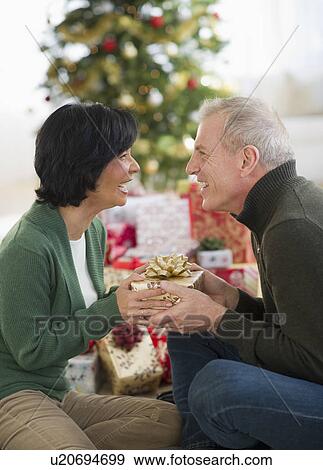 Stock Photo - Happy mature couple on christmas time. Fotosearch