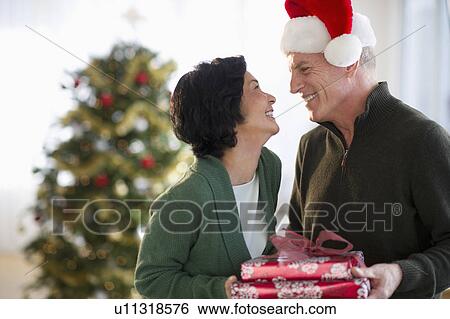 Stock Photograph - Happy mature couple on christmas time. Fotosearch
