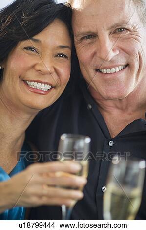 Picture - Happy mature couple with flutes. Fotosearch