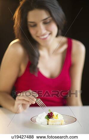 Happy woman eating dessert, studio shot View Large Photo Image Stock Photo - Happy woman eating dessert, studio shot. Fotosearch