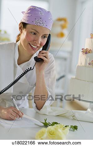 Happy young woman taking order near wedding cake View Large Photo Image Stock Photograph - Happy young woman taking order near wedding cake. Fotosearch