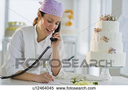 Happy young woman taking order near wedding cake View Large Photo Image Stock Photography - Happy young woman taking order near wedding cake. Fotosearch