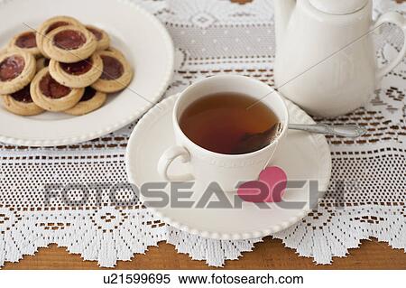 Stock Photography - Heart shaped biscuit with cup of tea. Fotosearch