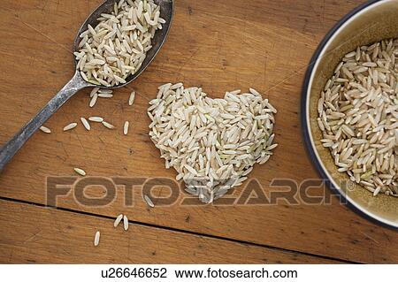 Stock Image - Heart shaped rice with spoon and bowl. Fotosearch