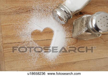 Stock Photograph - Heart shaped spilt salt on table. Fotosearch